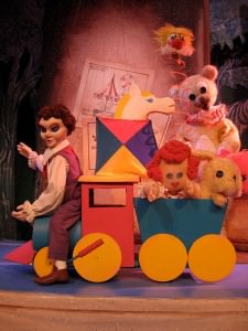 Tom Piper ferries a load of toys for shipment to good boys and girls in "Toyland," the Puppet Co.'s take on Victor Herbert's operetta, "Babes in Toyland, Photo courtesy of The Puppet Co.