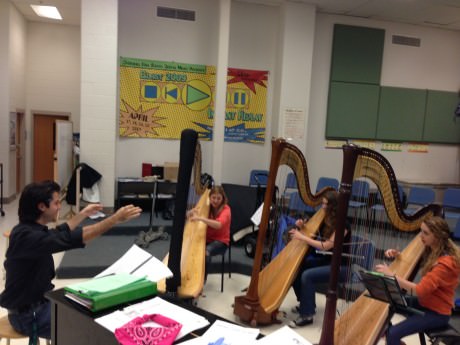 Kristofer Sanz rehearsing with harpists Monika Vasey, Vivian Franks, and Nora Kelsall.
