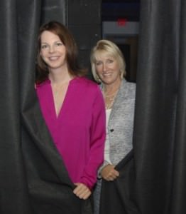 Janet Luby, Artistic Director and co-founder of the Bay Theatre Company, and Belinda Fraley Huesman, executive director of the Chesapeake Arts Center, peer out through the stage curtains of the Studio 194 Theatre at Chesapeake Arts Center. The two hope Bay Theatre will become a permanent resident at the Brooklyn Park-based center. Photo courtesy of Capital Gazette.com 9/22/13.