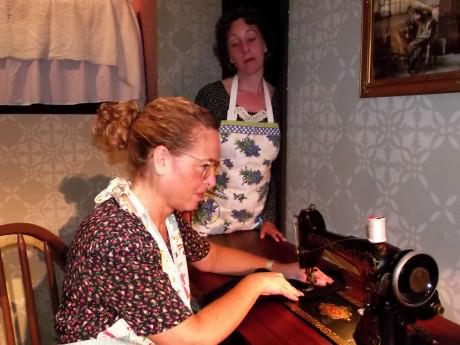 Jill Goodrich (Blanche) at Sewing Machine and Nora Zanger  (Kate). Photo by Roy Peterson. 