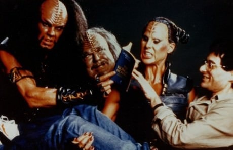 Author Marc Okrand photographed with actors who played Klingons in 1989’s Star Trek V: The Final Frontier—from left: Todd Bryant (Klaa), Charles Cooper (Korrd), and Spice Williams (Vixis). Says Marc: “The picture was taken when, for whatever reason, Spice asked me how much I weighed.  I told her, and she said she could curl more than that and picked me up.  I guess I had been torturing them by making them learn the language.”  The book in the picture is the first edition of Marc’s The Klingon Dictionary.Photo: Courtesy of Marc Okrand.
