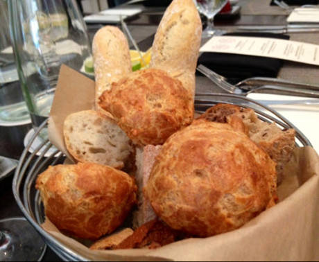 A basket of gougeres and assorted in house baked breads.