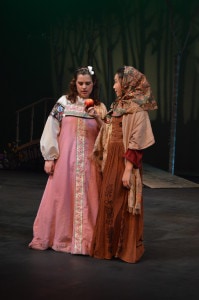 Snow White (Zoe Rocchio) is greeted with an apple from the Crone (Gabrielle Schaubach). Photo by Larry McClemons.
