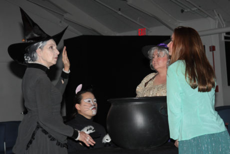 Witches: Granny Weatherwax (Anne Hull), Greebo (Marie Nearing), Nanny Ogg (Linda Pattison), and Magrat (Margaret Hudson) gather around the cauldron. Photos by Jon Gardner.