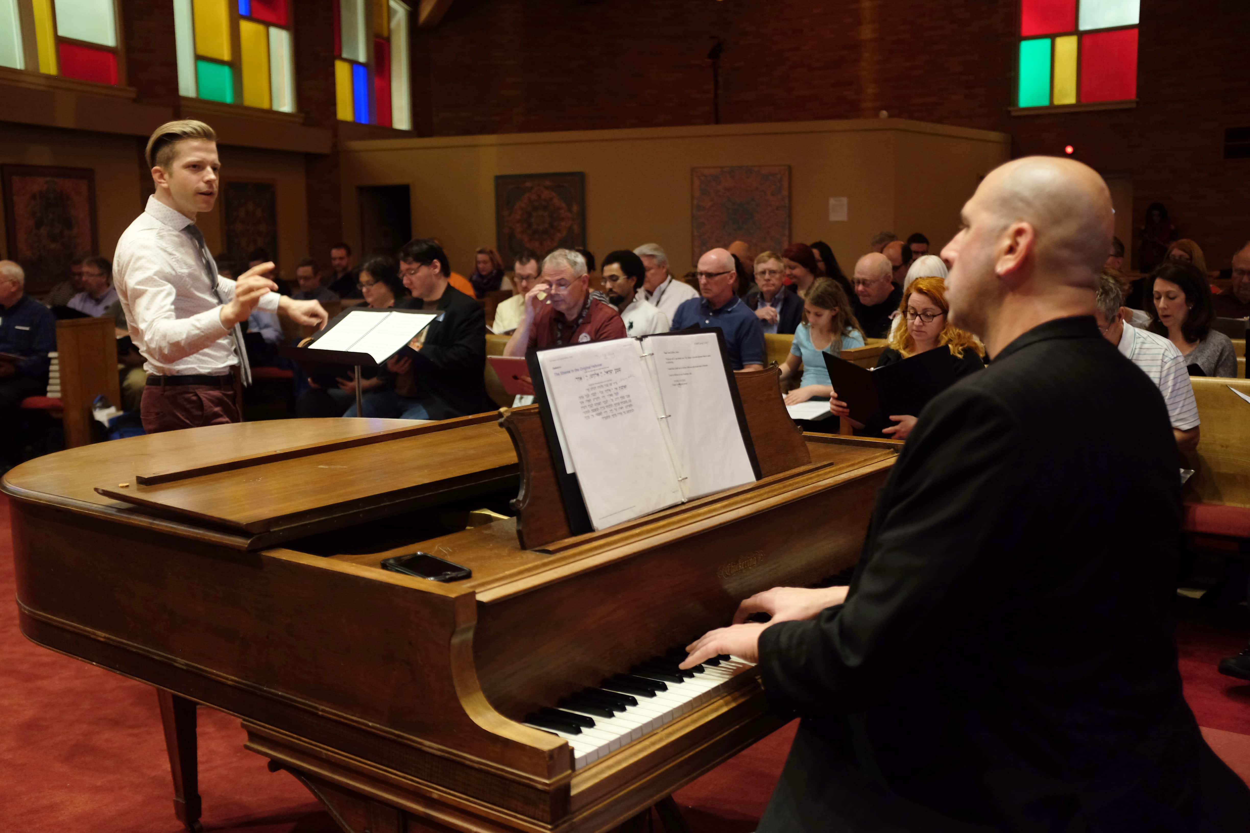 Composer Jeremy Schonfeld and Music Director David Bloom rehearse Iron & Coal. Singers from the Alexandria Harmonizers pictured in the background. Photo by Gabrielle Tillenburg. 