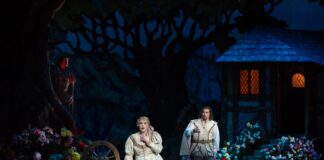 The devil (Raymond Aceto) looks on as Faust (Marcelo Puente) woos Marguerite (Erin Wall) in WNO's production of 'Faust.' Photo by Scott Suchman.