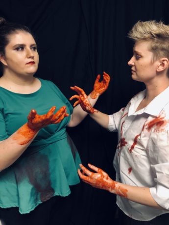 Lady Macbeth (Leandra Lynn) and Macbeth (Sarah Pfanz) with blood on their hands. Photo courtesy of Britches and Hose Theatre Company.