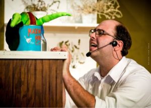 Seymour (Maverick McKee) begs Audrey II to "Grow For Me" in the Potomac Playmakers' production of 'Little Shop of Horrors.' Photo by Perk Hull Design.